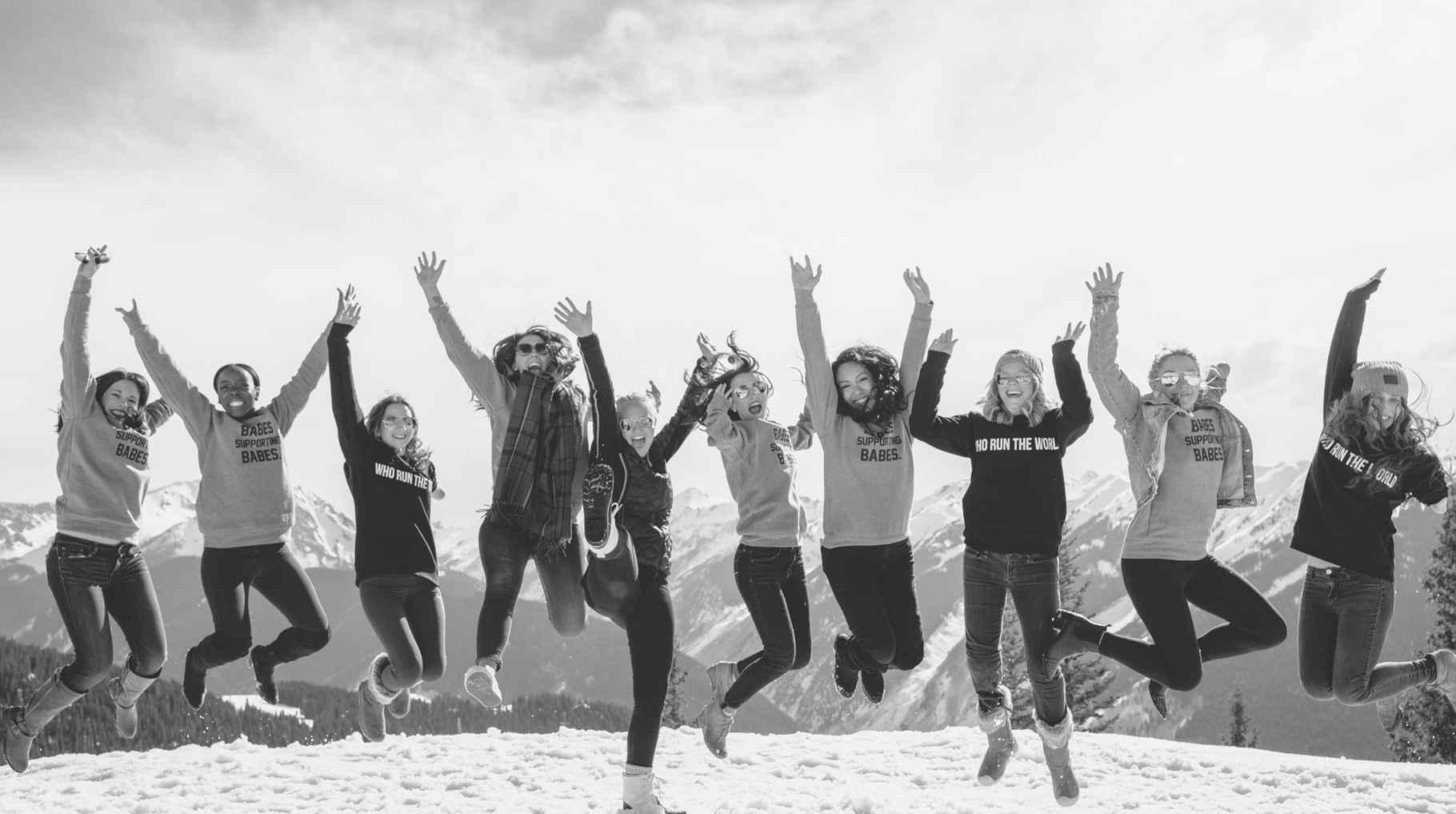 Group of nominees jumping for a picture on top of a snowy mountain